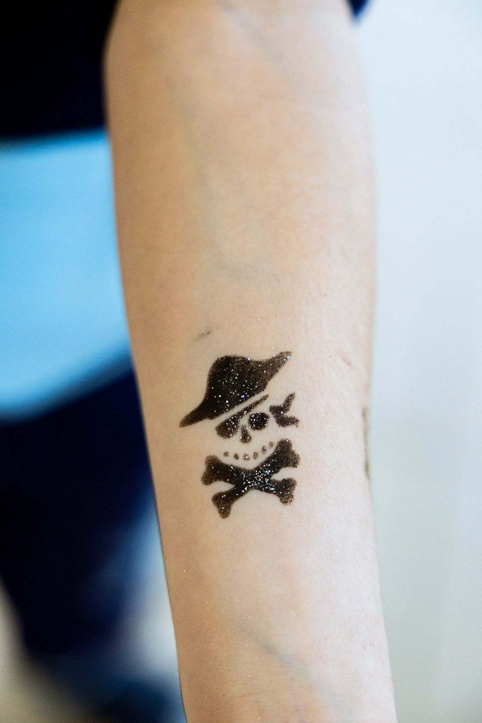 Un tatuaggio finto con il teschio dei pirati su un avambraccio